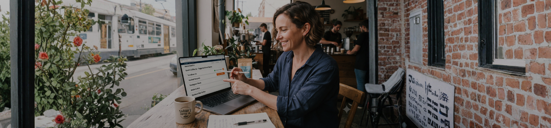 Australian small business owner reviewing AI-suggested brand names on a laptop while considering a trade mark.